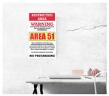 area 51 warning sign restricted area 13" by 22" vintage style show print poster being displayed on a wall by a desk